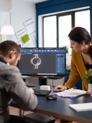 Coworkers engineer architects working on modern cad program developing construction metalic components. Industrial designer studying prototype idea on pc showing digital software with gears